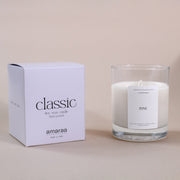 Classic soy wax candle in clear glass jar with pine scent, next to branded box